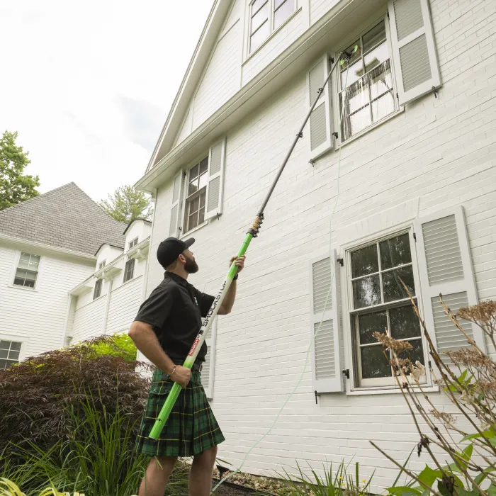 a person holding a broom outside a house