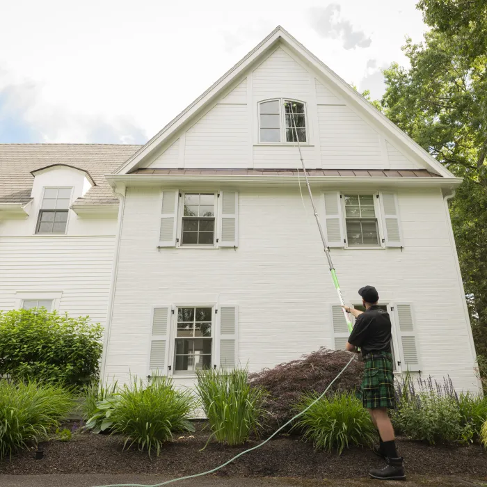 a person holding a rope in front of a house