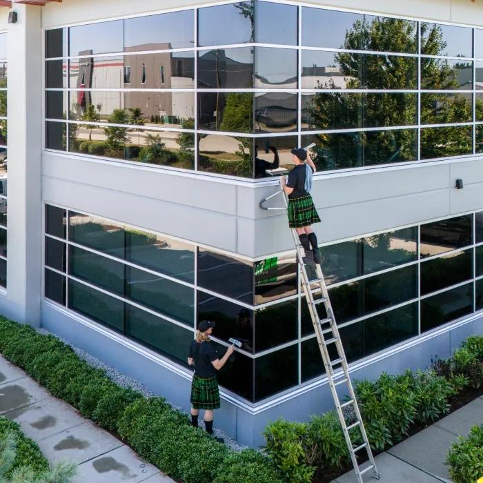 a couple of people on a ladder outside a building