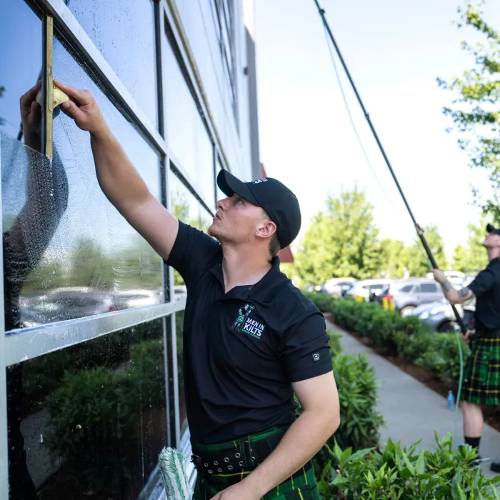 two men in kilts washing windows