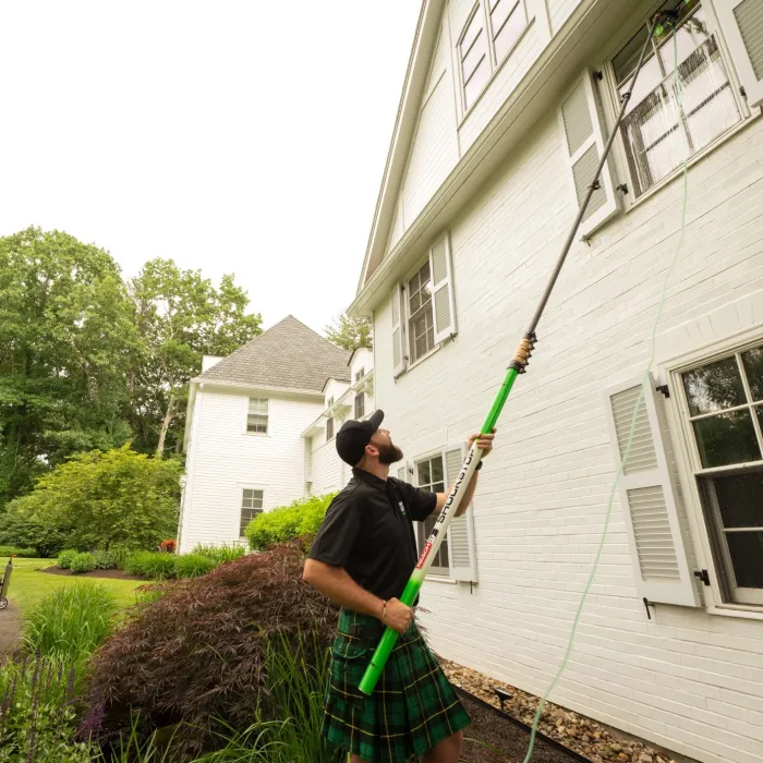 a man holding a broom outside a house