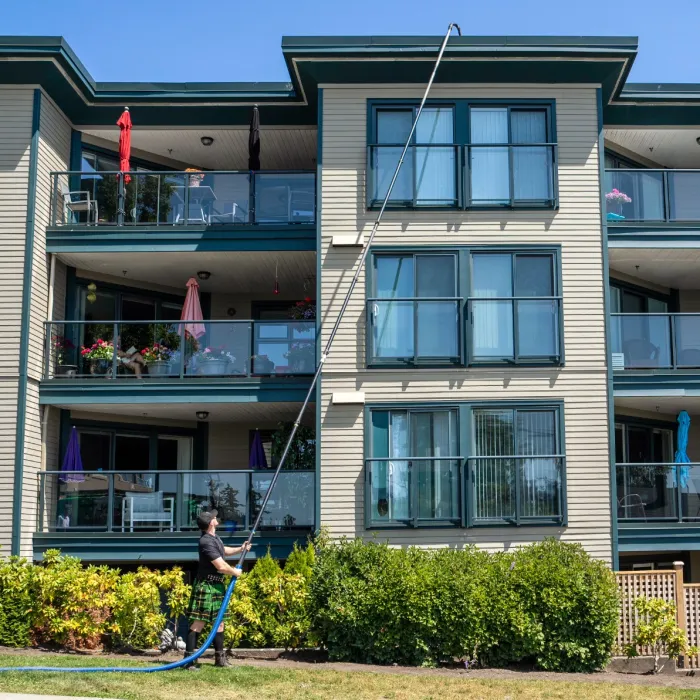 a person playing with a blue hose in front of a building