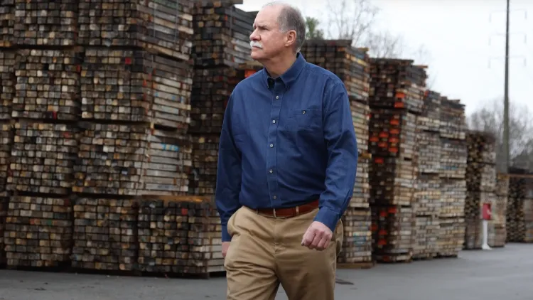 a man standing in front of a pile of bricks