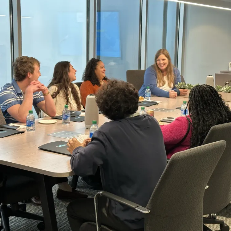 Group of diverse professionals engaged in discussion during a business meeting in a modern conference room.