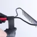 a hand holding a black and red barbell