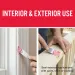 Hands applying pink filler to repair interior trim and exterior wood surface with putty knife for sealing.