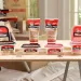 Various JB Weld wood filler products displayed on a wooden board in a workshop setting with natural light.