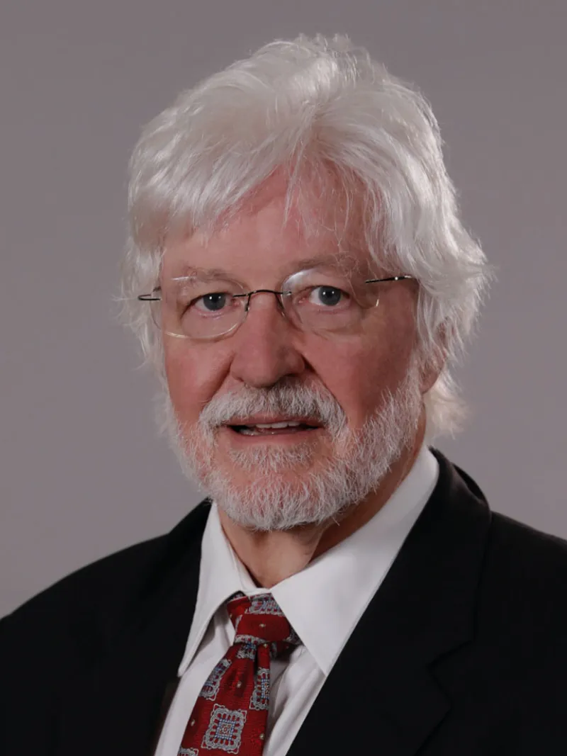 a man with white hair and glasses