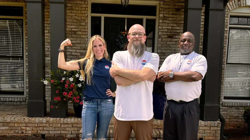 a group of people posing for a photo in front of a house