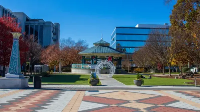 a courtyard with a fountain and buildings in the background