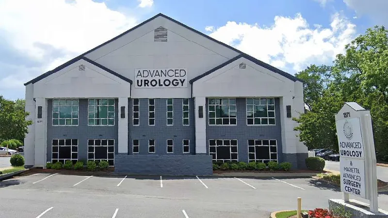 Modern Advanced Urology medical building with parking lot and clear sky in the background.