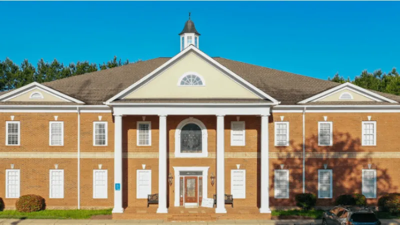 a large brick building with a parking lot in front of it