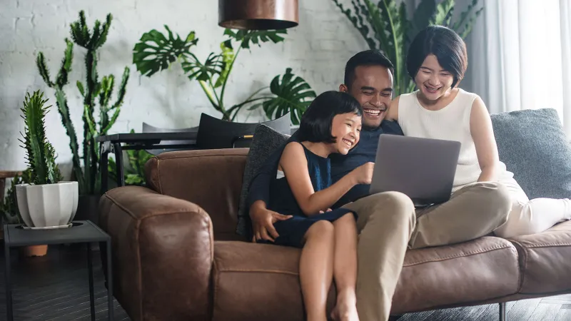 a group of people sitting on a couch with a laptop