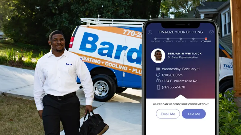 A technician walking towards a service van while holding a smartphone displaying booking details.
