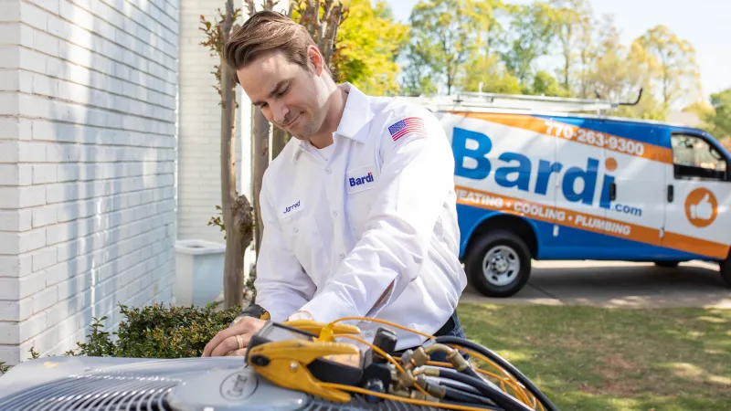 Air conditioner repair technician diagnosing AC unit