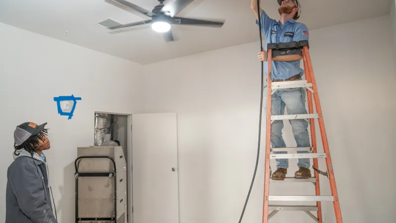 a person on a ladder painting a room