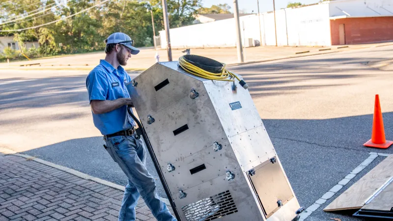 a man standing next to a large metal box