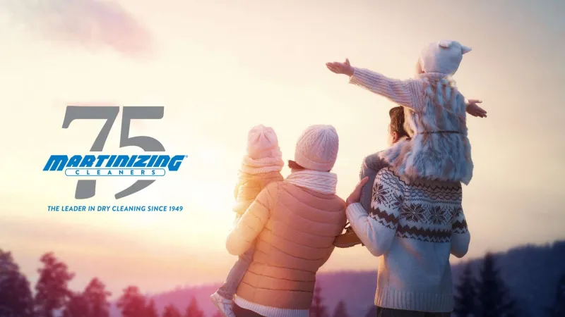 Family of four enjoying winter sunset outdoors with Martinizing Cleaners 75th anniversary logo in background.
