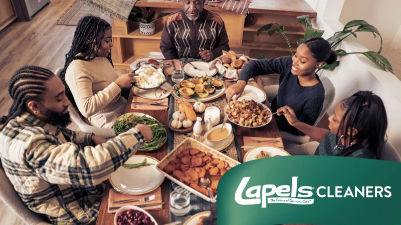 Family enjoying a festive meal together around a table filled with traditional dishes and sides during a gathering.
