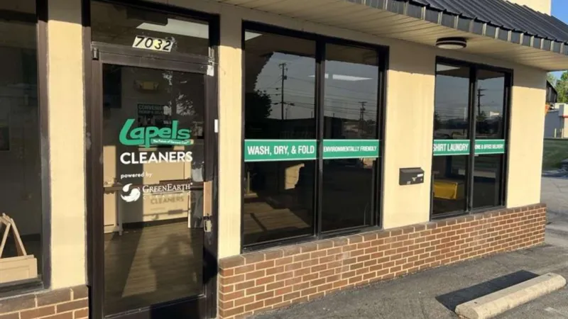 Front view of Lapels Cleaners storefront featuring green signs advertising wash, dry, fold, environmentally friendly services.