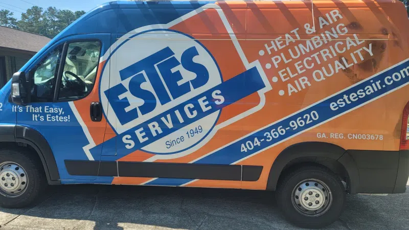 Estes Services van with branding for heat, air, plumbing, and electrical services parked outdoors under a ladder.