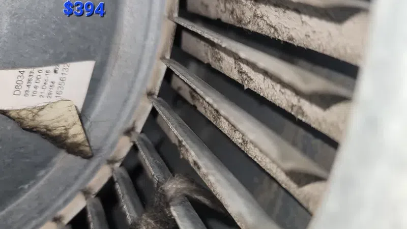 Close-up of dirty HK10A blower wheel with dust buildup and price $394 for cleaning service