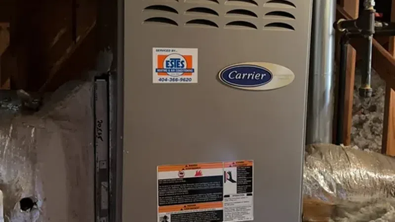 Carrier furnace installed in a basement with ducts and control panel visible in the background