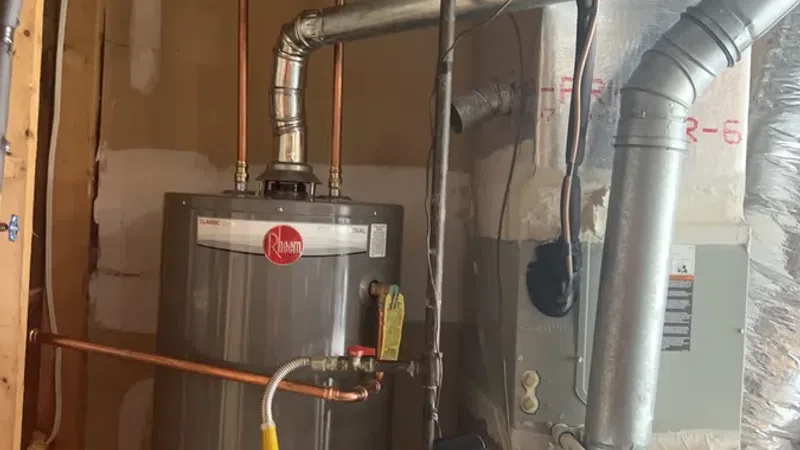 Rheem water heater and Ultra 80 furnace installed in a utility room with visible pipes and ductwork.