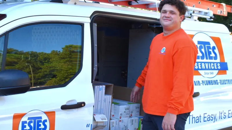 Estes Technician standing next to a Estes van with air filters on the front