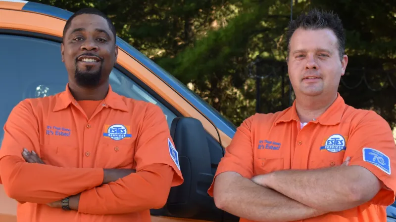 Two Estes Services Technicians in front of a van