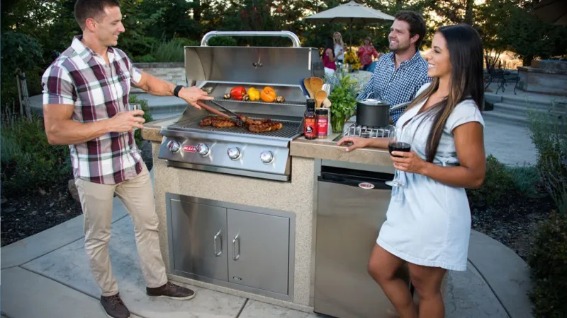 a group of people standing around a grill with food on it