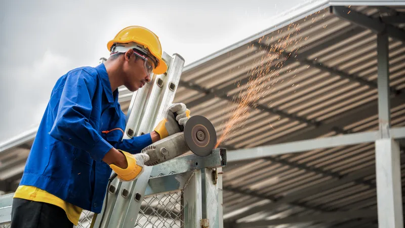 a man wearing a hard hat and protective gear working on a roof