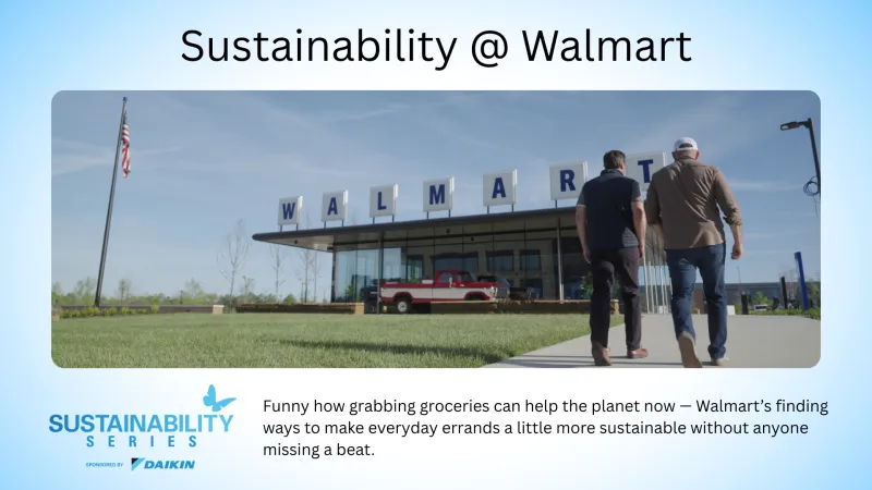Two people walk toward a Walmart store under a clear sky with a vintage red truck parked outside