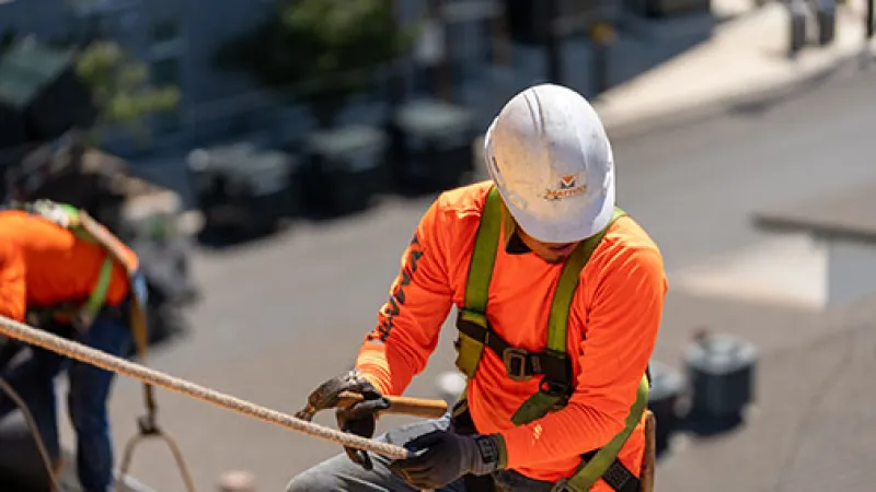 Mattco Roofing worker on steep slope roof with fall protection harness Texas