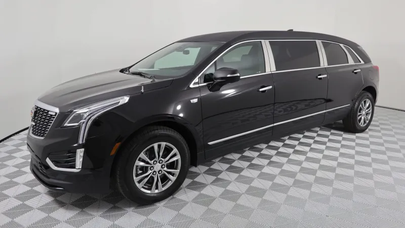 Black Cadillac XT5 luxury SUV showcased at a showroom on a patterned floor.