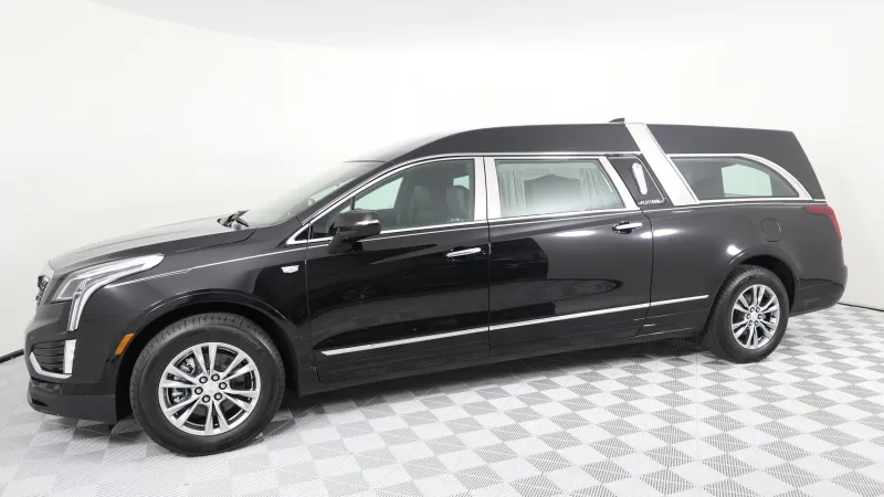 A sleek black Cadillac funeral hearse with elegant design and spacious interior.