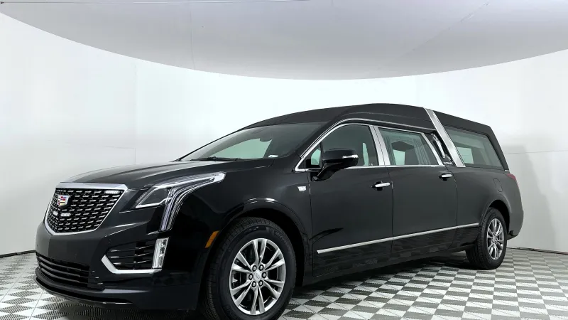 Black Cadillac hearse with extended rear compartment and sleek design in white studio setting
