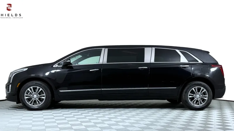Side view of a sleek black luxury SUV with chrome accents on a checkered floor.