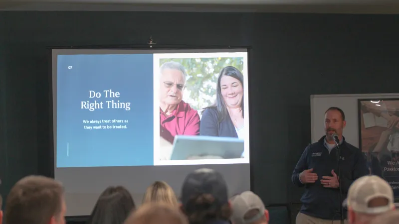 Man giving presentation to audience with slide titled Do The Right Thing and image of two people using a tablet.