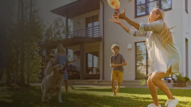 a group of people playing with a dog in a yard