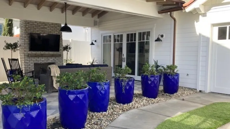 Azalea filled pots create a beautiful and functional border between the driveway and the outdoor living area 