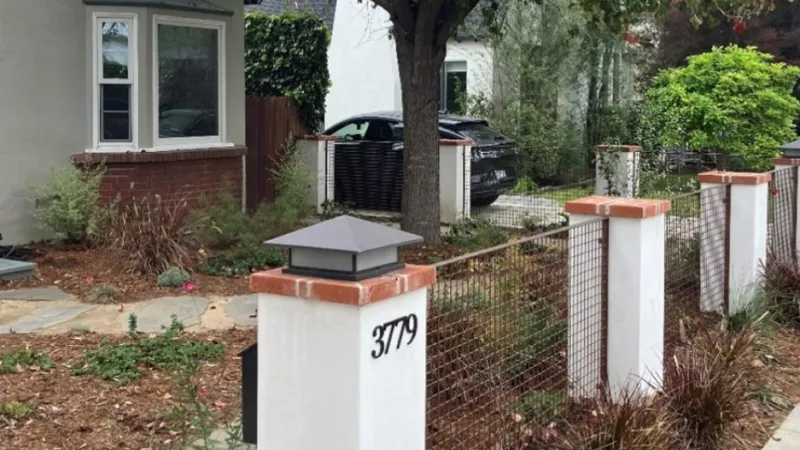Modern front yard with white fence posts, wire mesh fencing, greenery, and house number 3779 visible.