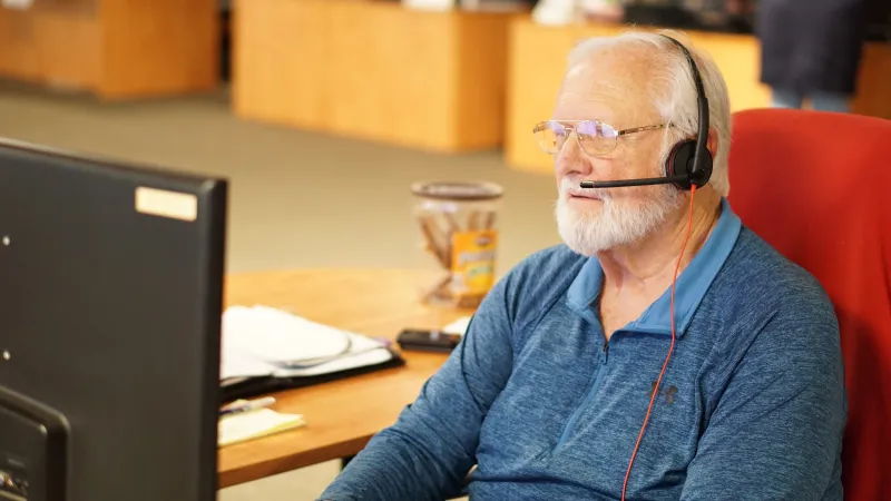 a man wearing headphones and sitting at a desk