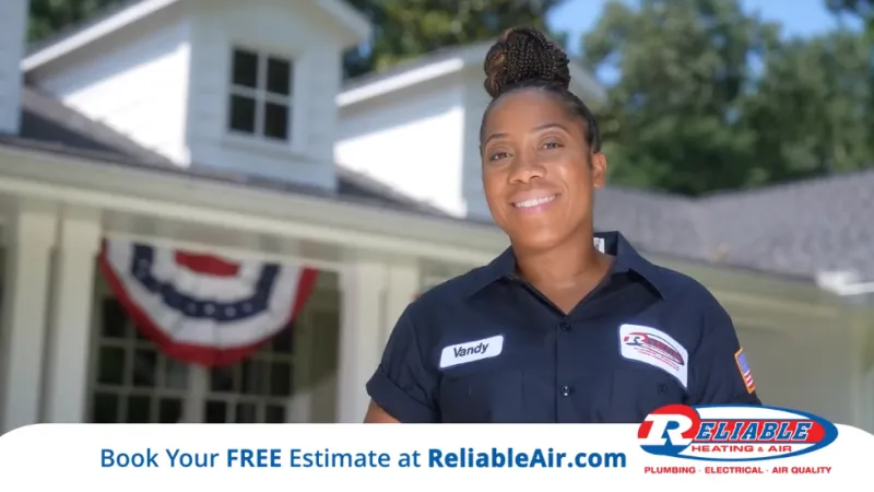 Smiling technician in uniform standing in front of a house, promoting Reliable Air services with flag decorations.