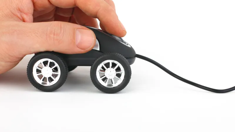 a hand holding a small black and silver electric vehicle