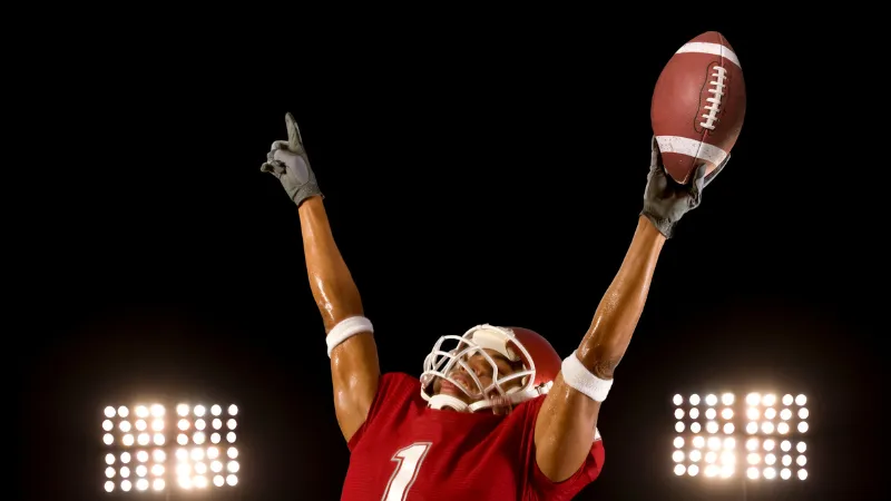 a football player holding his helmet up