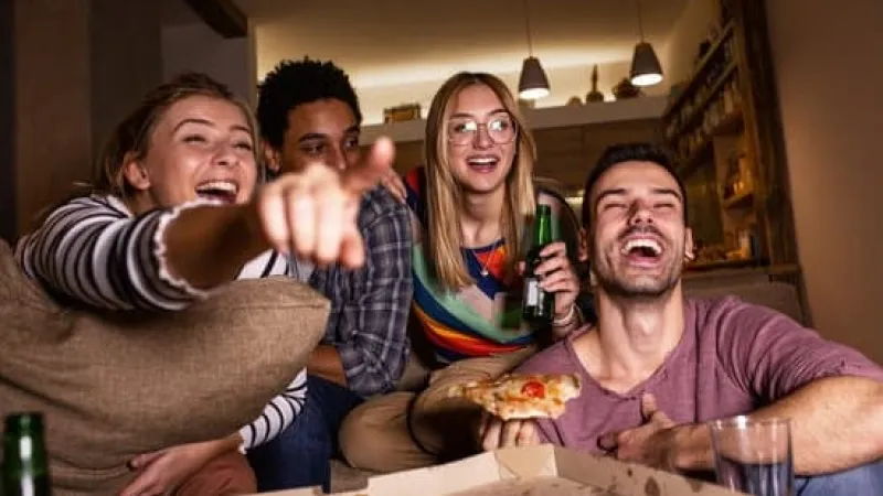 a group of people sitting at a table with pizza