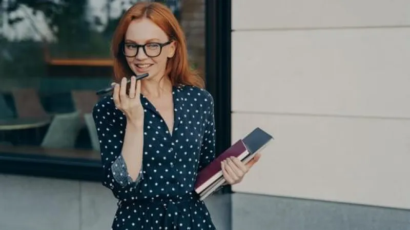 a woman holding a book and a pen