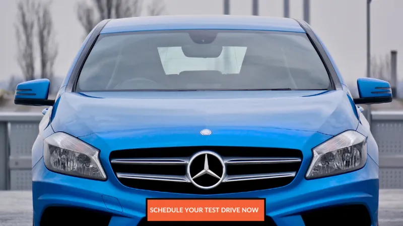 Front view of a blue Mercedes-Benz car with prominent logo and sleek design in an outdoor setting