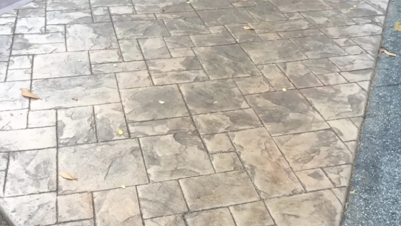 Textured stamped concrete driveway with a charming finish, highlighting intricate patterns and subtle color variations.